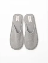 Pantuflas de algodón color gris melange, con diseño abierto y etiqueta de marca en la plantilla.