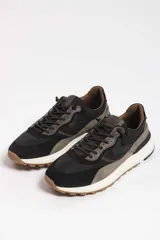 Zapatillas deportivas color crema con detalles en beige, negro y blanco.