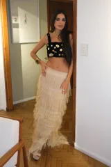 Pollera larga de tiro alto, confeccionada en capas de flecos color fucsia que crean un efecto de movimiento y textura.
