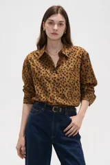 Camisa de algodón de manga larga, con estampado de lunares, cuello camisero y cierre frontal de botones.