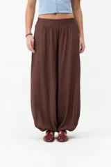 Pantalón babucha color marrón, de corte amplio y fluido, con cintura elástica y botamangas ajustadas.