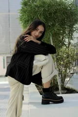 Botas de cuero negro con caña media, cordones y suela track.