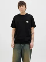Remera negra de algodón con cuello redondo, manga corta y fit relajado. Presenta un pequeño estampado en el pecho con la inscripción "Originals".