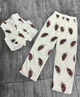 Conjunto blanco con estampado de hojas color borgoña, compuesto por un chaleco con botones y un pantalón de corte recto.