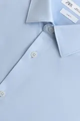 Camisa de hombre color beige claro, de corte slim fit, con cuello italiano, manga larga y cierre frontal de botonadura.