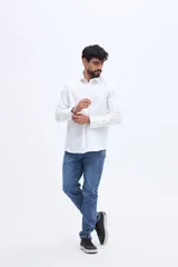 Camisa de manga larga de algodón color blanco, con cuello camisero tradicional, cierre frontal abotonado y calce semi slim.