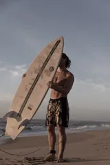 Short de baño para hombre con diseño combinado de paneles negros lisos en los laterales y estampa botánica tropical en el frente y la espalda. Cuenta con cintura elástica, cordón de ajuste negro y bolsillos laterales.
