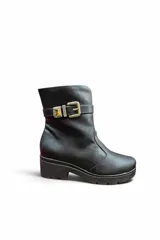 Bota corta de cuero color marrón con suela track y taco bloque. Incluye una tira decorativa en el tobillo con hebilla metálica dorada.
