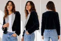 Chaqueta corta de terciopelo azul marino con solapas en contraste de color gris claro. Presenta un diseño estructurado, cierre frontal y bolsillos laterales con solapa.