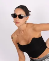 Corset negro de corte recto con escote asimétrico, confeccionado en tela elastizada con cierre en la espalda.