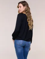 Blusa de modal y elastano color blanco, de silueta holgada, escote redondo amplio con elástico interno fruncido y mangas largas fluidas con puños ajustados.