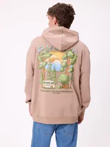 Canguro color beige con capucha y cordones ajustables. Presenta un estampado grande en la espalda con un paisaje de bosque, un lago, una van y el texto "DESIGNED FOR DISCONNECTION EST. 1985".