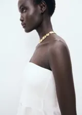 Top de estilo palabra de honor con diseño peplum en la cintura. Presenta un corte ajustado en el torso y un bajo con vuelo, confeccionado en un tejido estructurado.