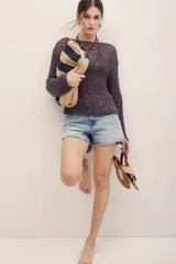 Sweater de punto calado color gris oscuro, de manga larga y diseño holgado.