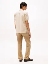 Camisa de corte regular confeccionada en puro algodón mil rayas con una sutil textura. Diseño integral de rayas verticales, cuello con botones, bolsillo de parche en el pecho, detalles distintivos de Tommy Jeans y parche con el logo de Tommy Jeans en el bolsillo.