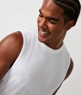 Musculosa deportiva de corte regular, color blanco, con cuello redondo y diseño minimalista. Confeccionada en tejido técnico de poliéster de secado rápido.