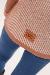 Sweater de punto color salmón con rayas verticales en relieve. Tiene cuello redondo y corte holgado.