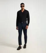 Pantalón de sastrería corte slim, color azul marino, con cintura elástica, trabillas para cinturón, cierre tradicional y bolsillos laterales.