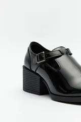 Zapato color crema con diseño tipo T-bar, tira con hebilla lateral y taco ancho de 6cm.