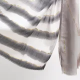 Pashmina rectangular de tejido ligero con estampado degradado en tonos grises y marrones, realzado con líneas horizontales de detalles dorados.
