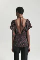 Top de viscosa estampada con escote a la base y detalle de cut out. Mangas cortas con volumen.
