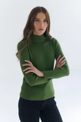 Polera de tejido morley color azul, con cuello alto y mangas largas, de corte ajustado al cuerpo.