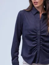 Camisa azul en símil suede, marca Ninety. Cuello con solapa y abertura central con botones. Delantera fruncida.