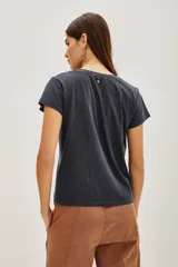 Remera de algodón color gris oscuro con cuello redondo y mangas cortas. Presenta un estampado frontal con motivos celestiales de sol, luna y nubes, con detalles de lentejuelas y la inscripción 'Claire de Lune'.