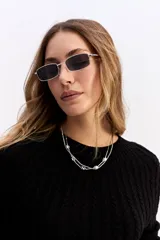 Buzo de punto negro con diseño de trenzas en relieve, cuello redondo y mangas largas.