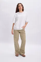 Pantalón de corte recto y holgado con estampa a rayas verticales en tonos verde, beige y marrón. Cuenta con cintura elástica y bolsillos laterales.