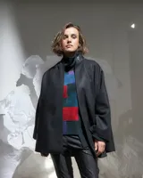 Sweater de lana merino afieltrada color verde oscuro con cuello alto y diseño de bloques de color en azul, rojo y violeta.