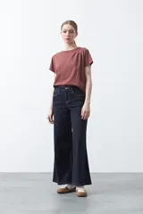 Remera básica de manga corta en color blanco, con cuello redondo y detalle de pliegues sutiles en los hombros.