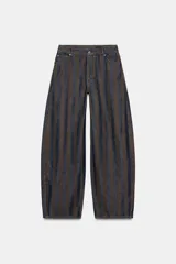 Jeans de tiro medio con corte barrel leg, confeccionados en denim con rayas verticales a contraste en tonos azul oscuro y marrón/tostado. Presentan cinco bolsillos y cierre frontal con cremallera y botón.
