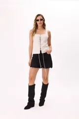 Corset blanco con finas rayas verticales negras, escote recto y ajuste frontal con cordones entrelazados.