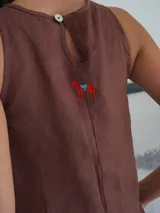 Vestido largo marrón de lino con detalle de cuero negro en la parte superior delantera y cartera trasera.