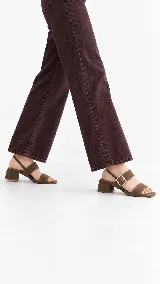 Sandalia de cuero color beige con taco cuadrado de 4 cm, tiras delanteras, tira ajustable con hebilla metálica dorada y tira elástica trasera.