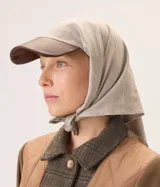 Gorro pañuelo color beige con visera de cuero marrón. El pañuelo es de algodón y se anuda bajo la barbilla.