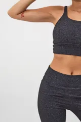 Calza deportiva larga color gris jaspeado, de tiro alto y corte ajustado.