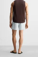 Short de baño celeste con estampado geométrico paisley, cintura elástica con cordón ajustable, bolsillos laterales y bolsillo trasero.