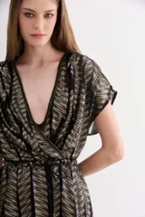 Vestido corto de tul con diseño de rayas en tonos dorados y negros, con escote en V cruzado, mangas cortas y lazo ajustable en la cintura. Incluye un viso interior con breteles regulables.