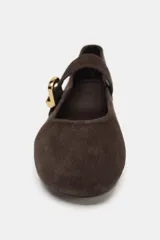 Zapato plano tipo bailarina confeccionado en serraje, con punta redonda y tira delantera ajustable con maxi hebilla metálica dorada.