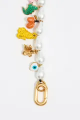 Pulsera de perlas irregulares con charms colgantes de motivos selváticos y cierre de mosquetón dorado.