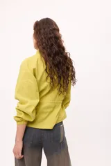 Chaqueta azul con cuello mao, mangas largas abullonadas y lazo en la cintura.