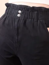 Pantalón de gabardina negro con cintura alta elástica tipo paperbag, cierre frontal con botones y corte recto.