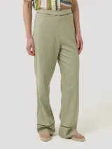 Pantalon de lino organico color verde militar, de corte recto y tiro alto, con sutil detalle de calado en la cintura y en el borde inferior.