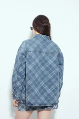 Sobrecamisa de jean con estampado de cuadros, corte relajado, cuello clásico y cierre frontal con botones metálicos.