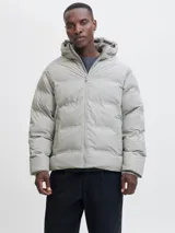 Campera puffer color gris claro, con capucha, cierre frontal con cremallera y diseño acolchado. Cuenta con puños internos acanalados y acabado resistente al agua.