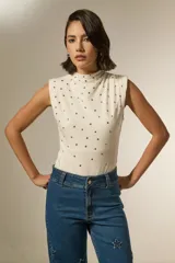 Body sin mangas de algodón, con cuello alto y diseño ajustado al cuerpo, decorado con tachas metálicas plateadas en la parte frontal.