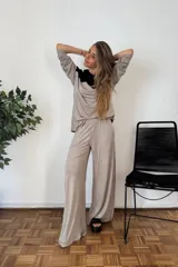 Sudadera tipo canguro con capucha y cordones, de manga larga y corte amplio. Presenta un diseño bicolor: la parte superior (hombros y capucha) es negra, y el resto del cuerpo y mangas son de color beige oscuro/topo.