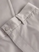 Pantalón de vestir color beige claro, de corte recto y ajuste regular, con cierre de botón y cremallera.